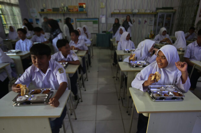 
Sejumlah siswa menyantap makanan saat pelaksanaan program Makan Bergizi Gratis (MBG) di sekolah Madrasah Tsanawiyah Negeri 4, Kopelma Darussalam, Banda Aceh, Aceh, Senin (14/4/2025). Program Makan Bergizi Gratis (MBG) tersebut digelar untuk 2.709 siswa penerima manfaat di sejumlah sekolah mulai dari tingkat Sekolah Dasar (SD) hingga Sekolah Menengah Atas (SMA) di wilayah Kota Banda Aceh. ANTARA FOTO/Ampelsa/nym.